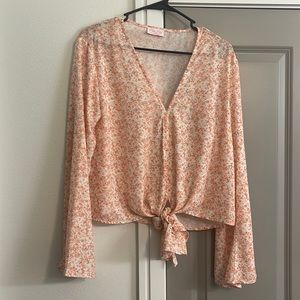 Pink Lily blouse with bell sleeves and floral pattern. Size Medium